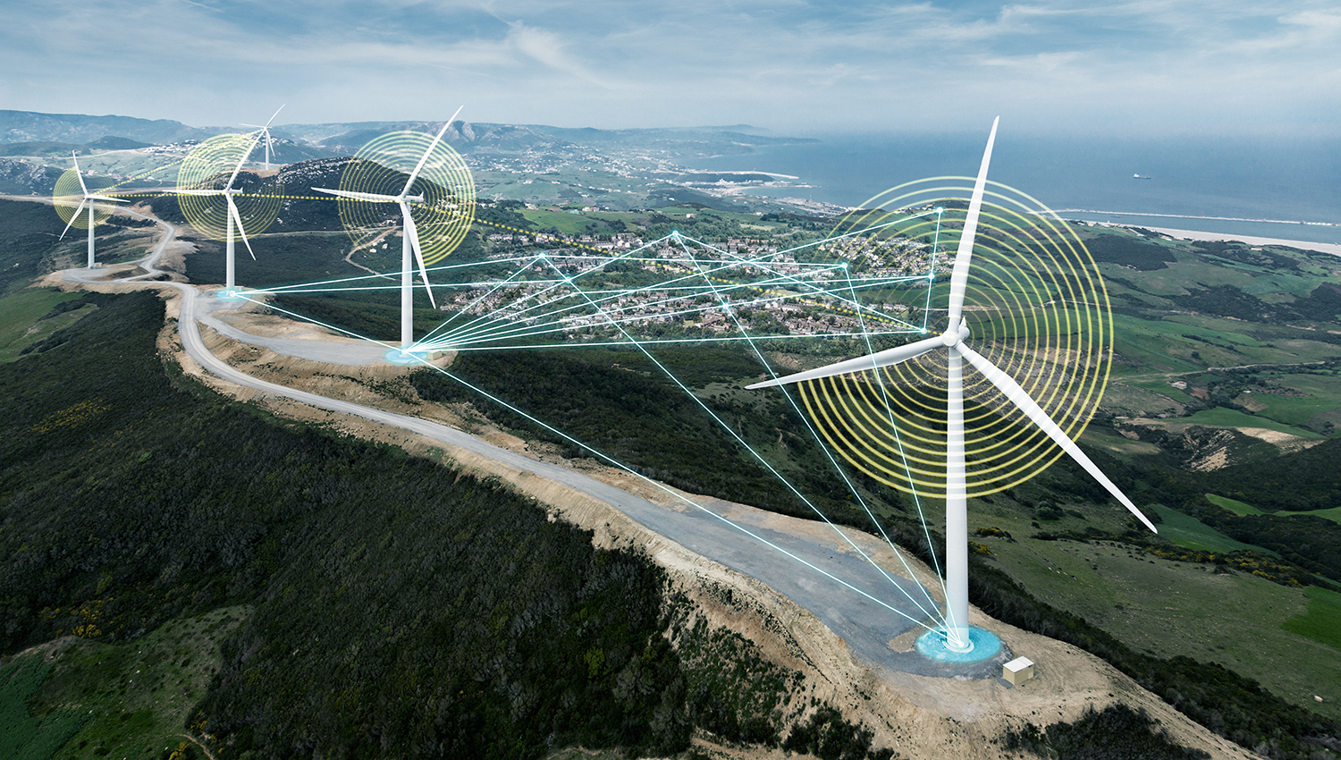 Four wind turbines on hills above city with digital overlay and ocean in background.