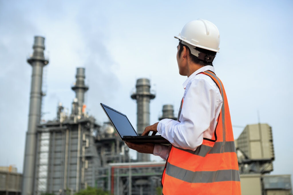 Engineer working at electric power plant with laptop