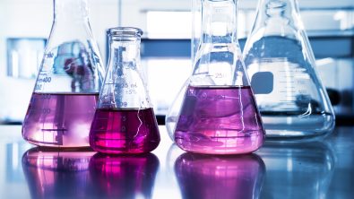 Purple glass flask in blue research chemistry science banner laboratory background