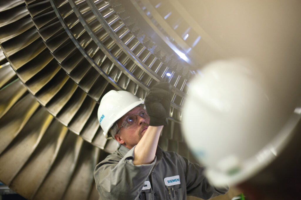 Two field technicians from Siemens working in product service.