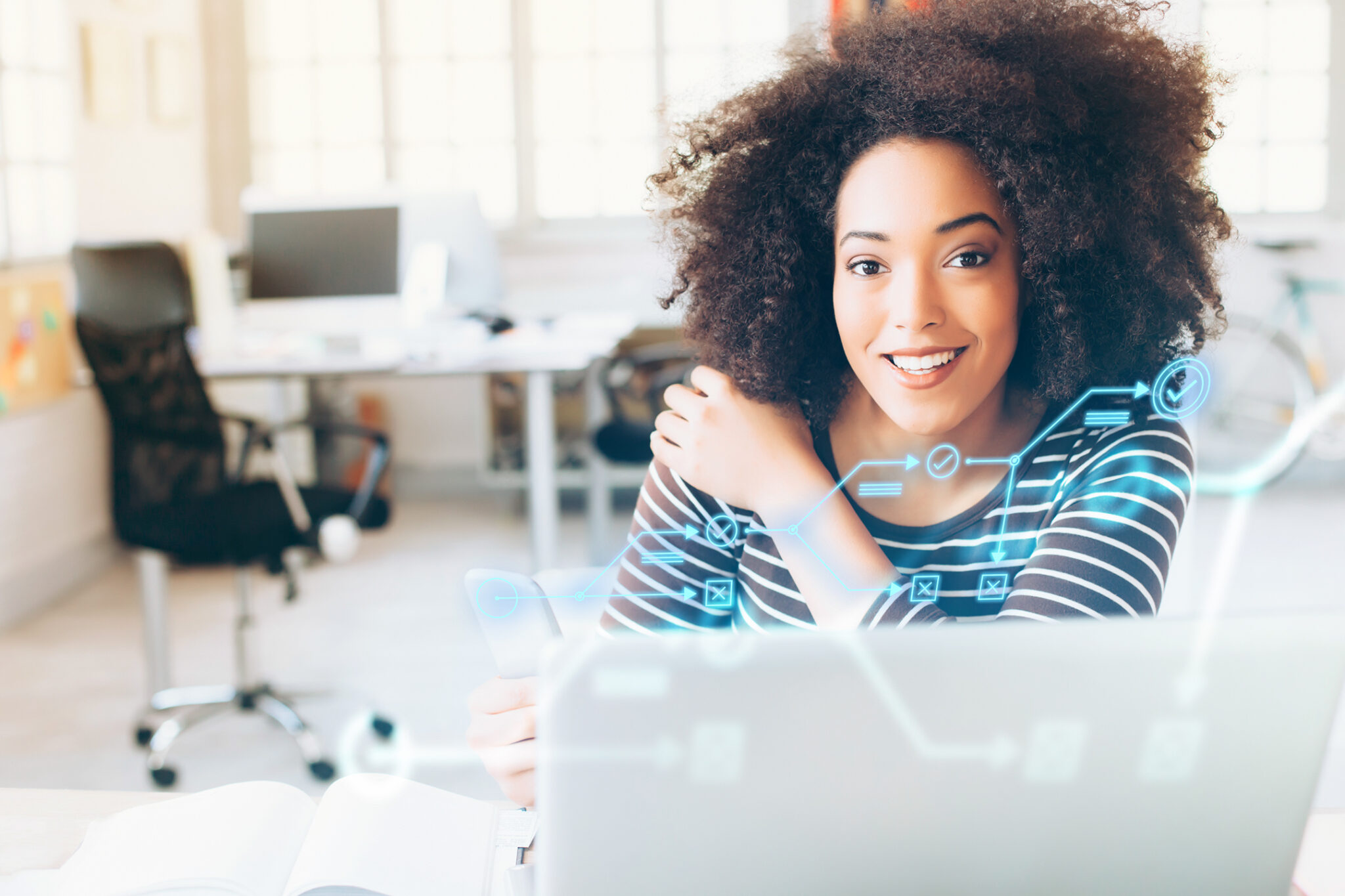 Woman smiling with a laptop in front of her in an office environment