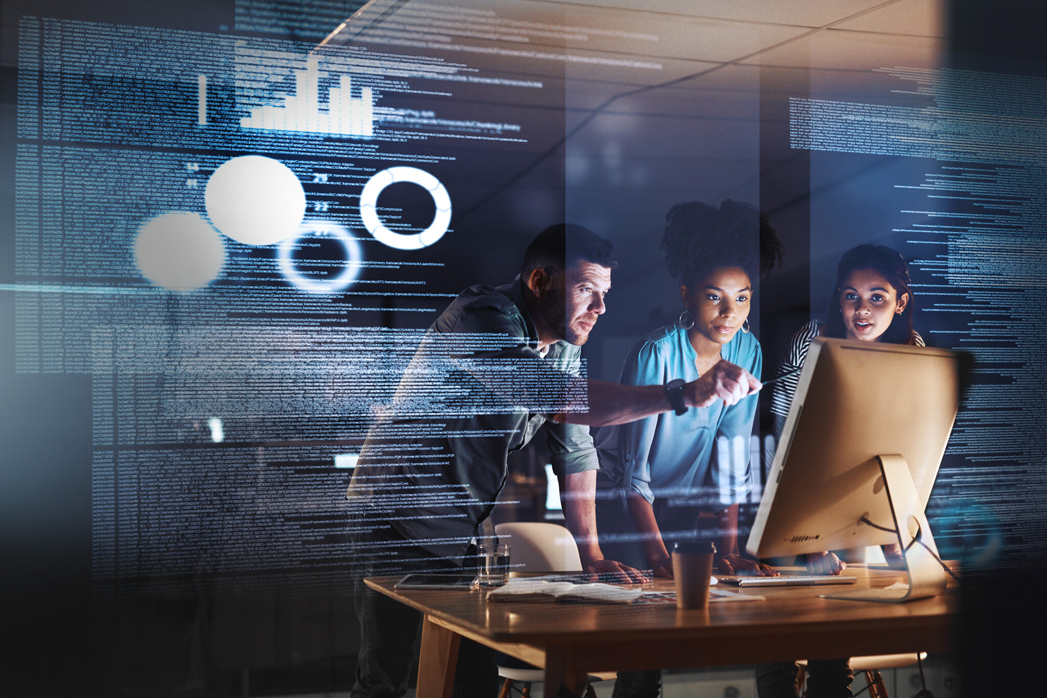 Shot of a group of programmers working together on a computer code at night