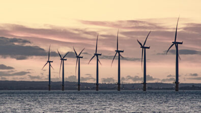 Wind turbines in front of a scenic waterway