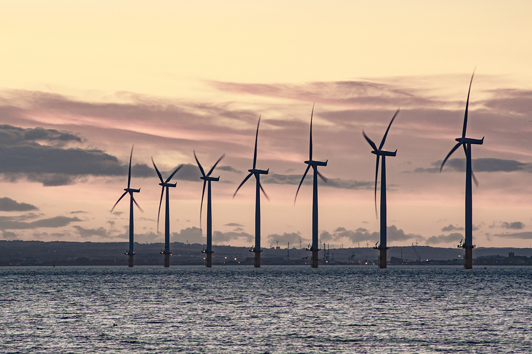Wind turbines in front of a scenic waterway