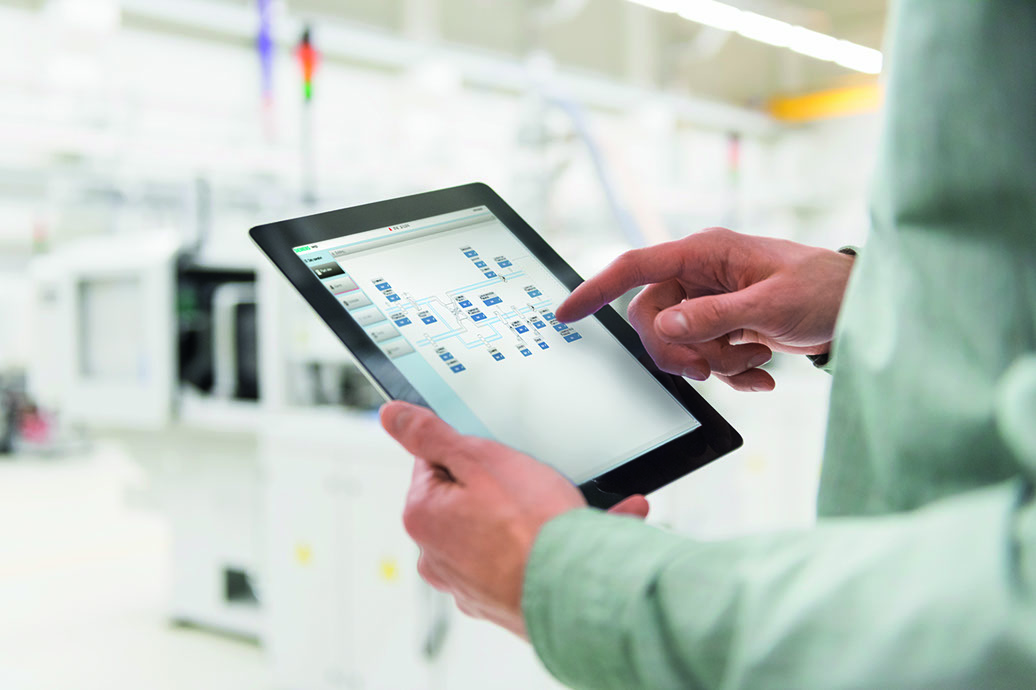 Male worker using digital tablet at tool manufacturing plant, focus on hands