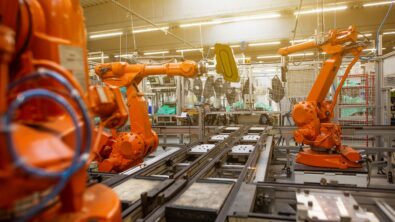 Orange machine arms in a manufacturing factory