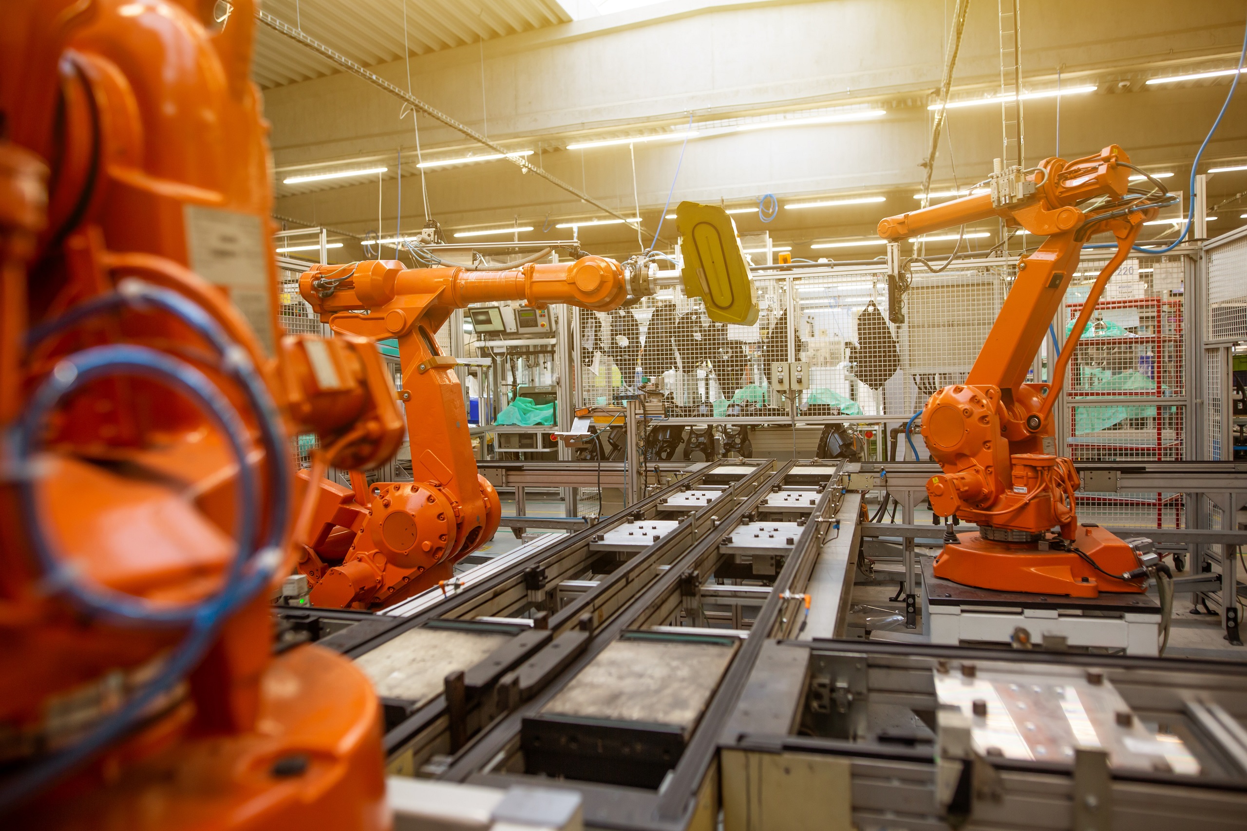 Orange machine arms in a manufacturing factory