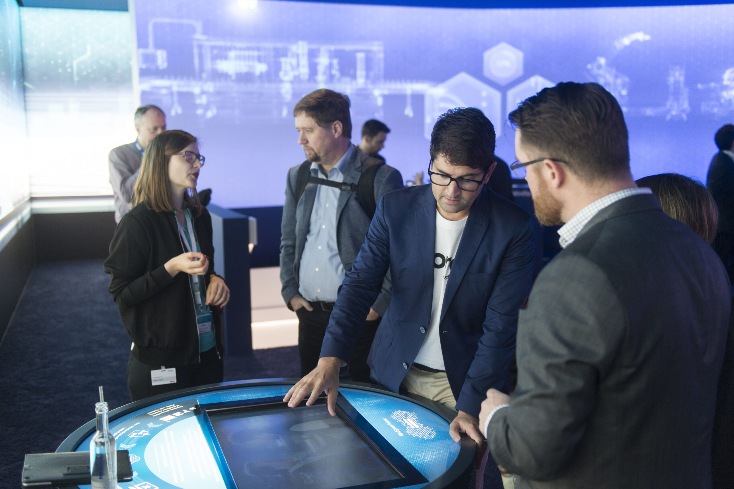 Group standing around a touch screen embedded in a round table