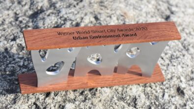 A medal and wood award with the words "Winner World Smart City Awards 2020 Urban Environment Award"