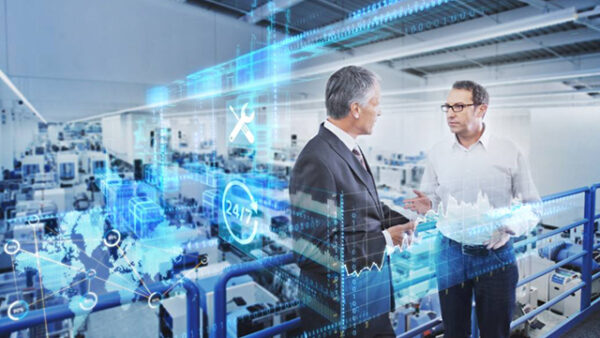 Two business men in factory shaking hands with a blue overlay of numbers and graphs over them