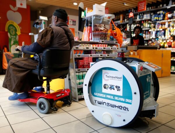 A man does his own shopping at a store using an autonomous robot, shaped and inspired by Star Wars R2D2, in a test for the delivery of groceries by Franprix supermarket chain in the 13th district of Paris, France, April 17, 2019.  REUTERS/Charles Platiau