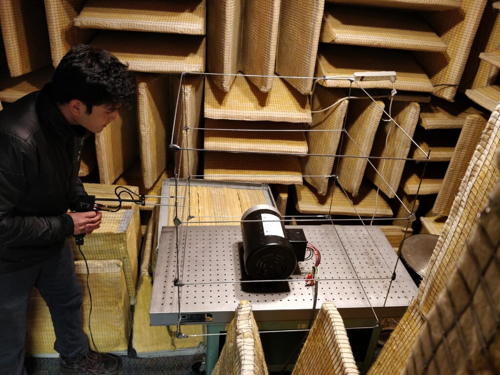 A student performs EV motor noise measurement in an anechoic chamber