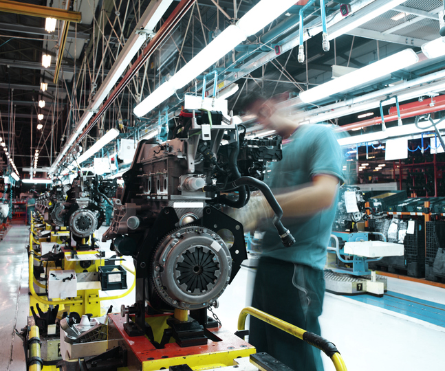 A man works on an engine in the production line