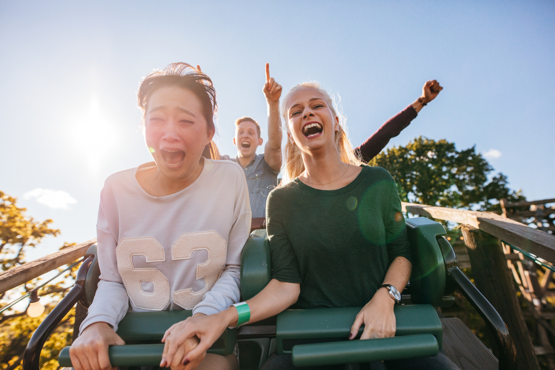Enthusiastic young friends riding amusement park ride