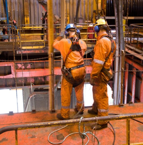 Two oil and gas industry workers wearing safety equipment