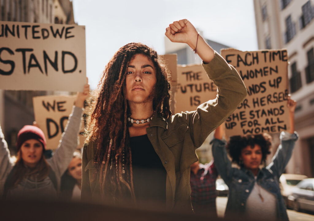 Woman leading a group of demonstrators on road.