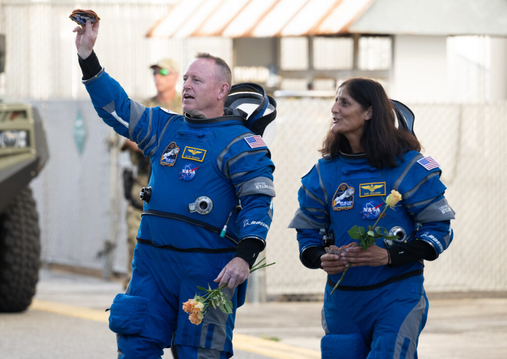 NASA astronauts Butch Wilmore, left, and Suni Williams, wearing Boeing spacesuits, are seen as they prepare to depart the Neil A. Armstrong Operations and Checkout Building for Launch Complex 41 on Cape Canaveral Space Force Station to board the Boeing CST-100 Starliner spacecraft for the Crew Flight Test launch, Wednesday, June 5, 2024, at NASA’s Kennedy Space Center in Florida. NASA’s Boeing Crew Flight Test is the first launch with astronauts of the Boeing CFT-100 spacecraft and United Launch Alliance Atlas V rocket to the International Space Station as part of the agency’s Commercial Crew Program. The flight test, targeted for launch at 10:52 a.m. EDT, serves as an end-to-end demonstration of Boeing’s crew transportation system and will carry NASA astronauts Butch Wilmore and Suni Williams to and from the orbiting laboratory. Photo Credit: (NASA/Joel Kowsky)