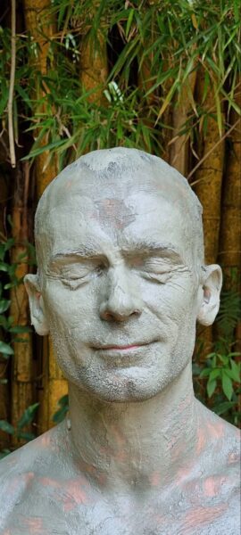 Daniel Scuzzarello with mud on face during a ceremony for healing and growth.