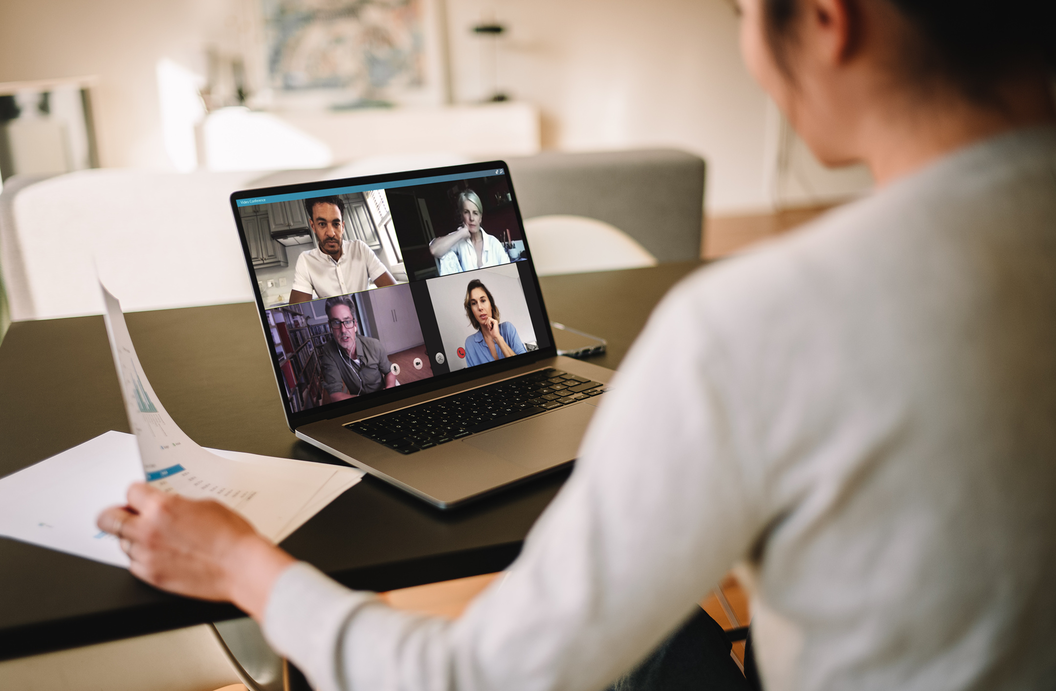Group of business people working from home, having video conference. Businesswoman having a video call with her team over a laptop at home.