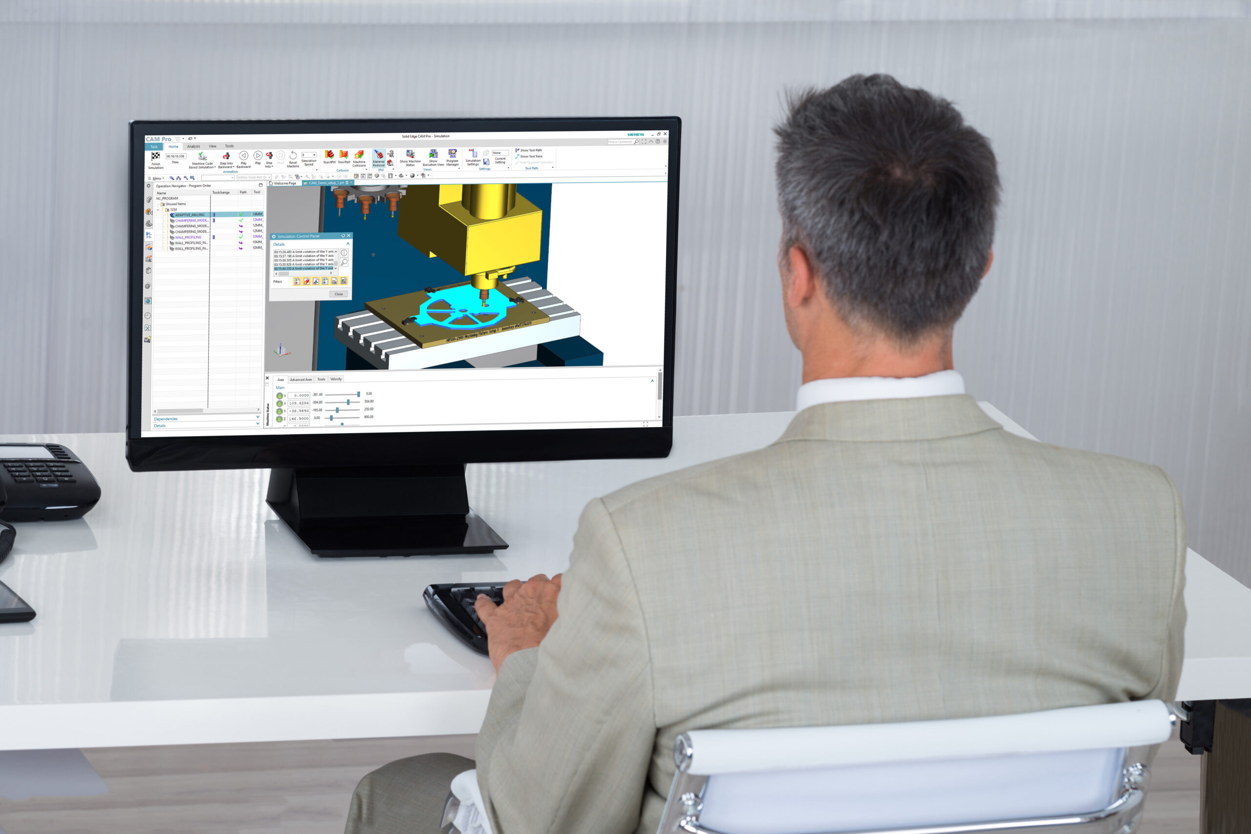 Man at computer in a suit working within Solid Edge CAM Pro