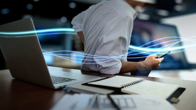 Solid Edge SaaS Hero Image, with waves of blue light and businessman using on smartphone as concept
