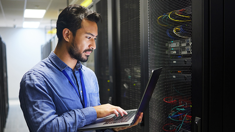 Man, engineering laptop and data center, server room inspection or system solution, coding and business network. IT person on computer for tech upgrade, gdpr programming and hardware problem solving.